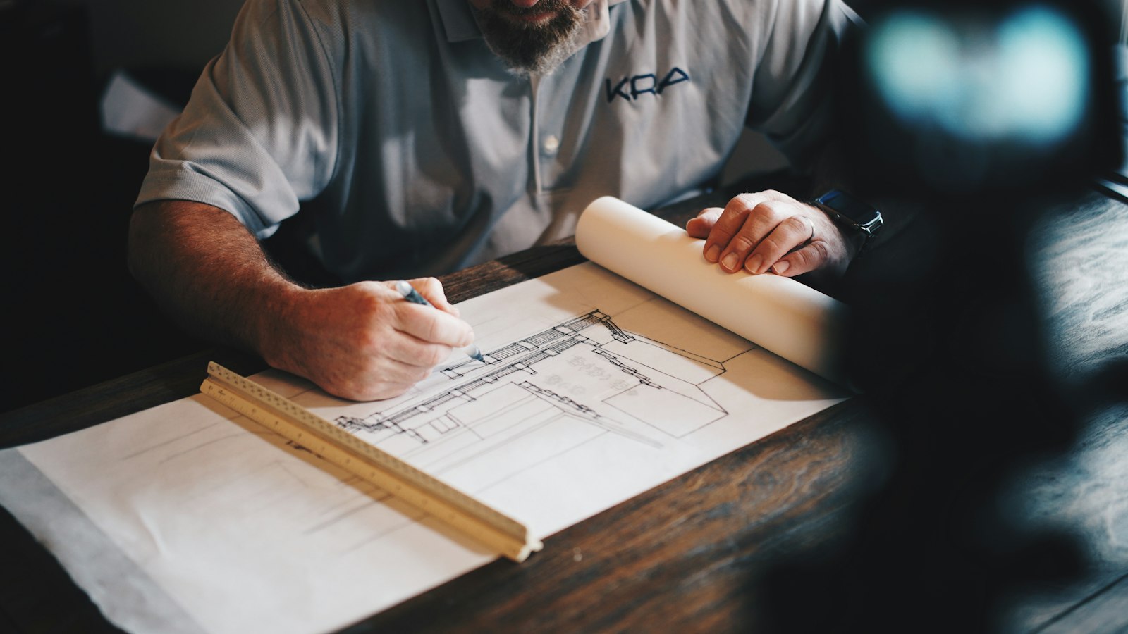 A designer marking a measured drawing of a home